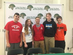 Students athletes stand together after signing to their schools.