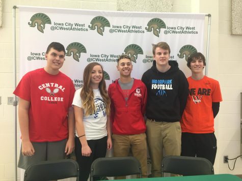Students athletes stand together after signing to their schools.