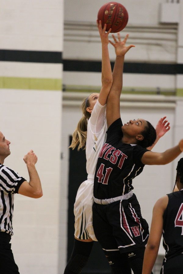 Logan Cook '18 tips the ball off against Waterloo West's Jada Draine '20 during the first quarter of the game on Friday, Feb. 9.