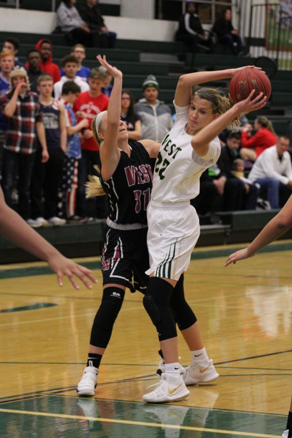 Logan Cook '18 keeps the ball away from Waterloo West's Lauren Conrey '20 during the first quarter of the game on Friday, Feb. 9.