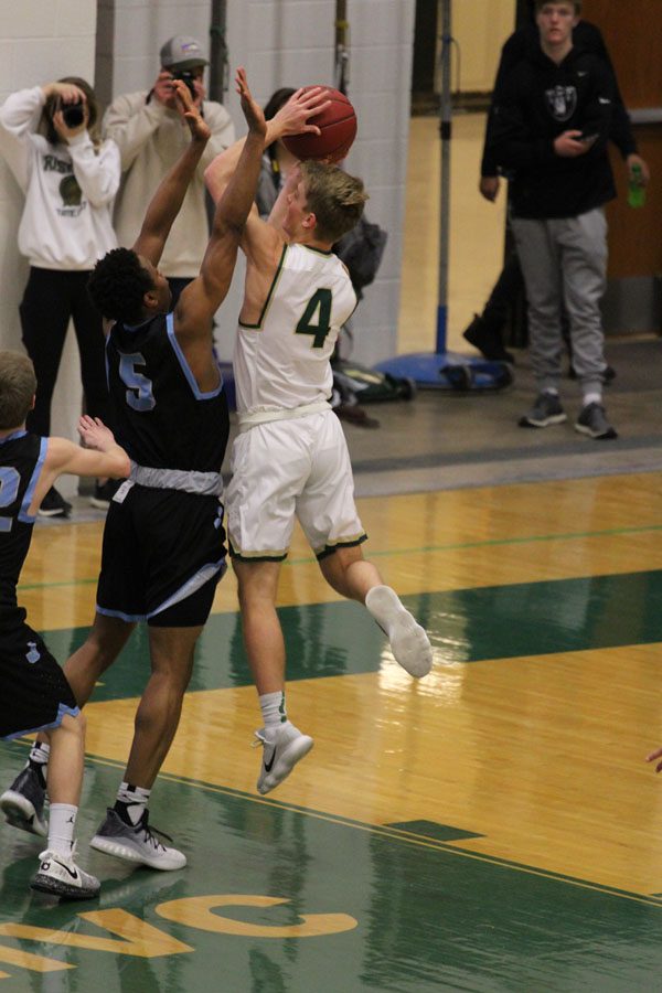 Evan Flitz '18 shoots a basket as Jefferson's Raejzuan Shockley '20 tries to block him on Tuesday, Feb. 13.