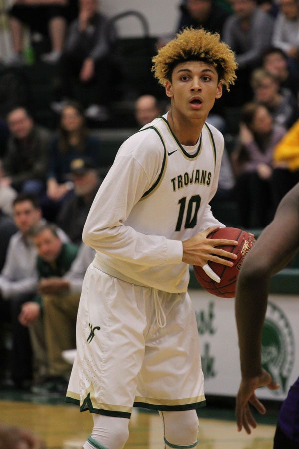 Seybian Sims '18 looks for someone to pass the ball to during the first half of the game on Saturday, Feb. 17.