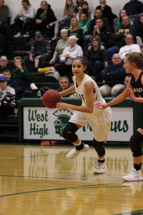 Cailyn Morgan '19 dribbles around the three-point line as she looks to pass the ball on Saturday, Feb. 17.