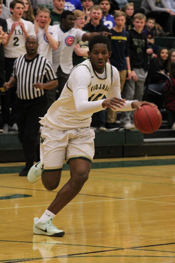 Hakeem Odunsi '18 dribbles the ball towards the basket during the first half of the game on Friday, Feb. 23.