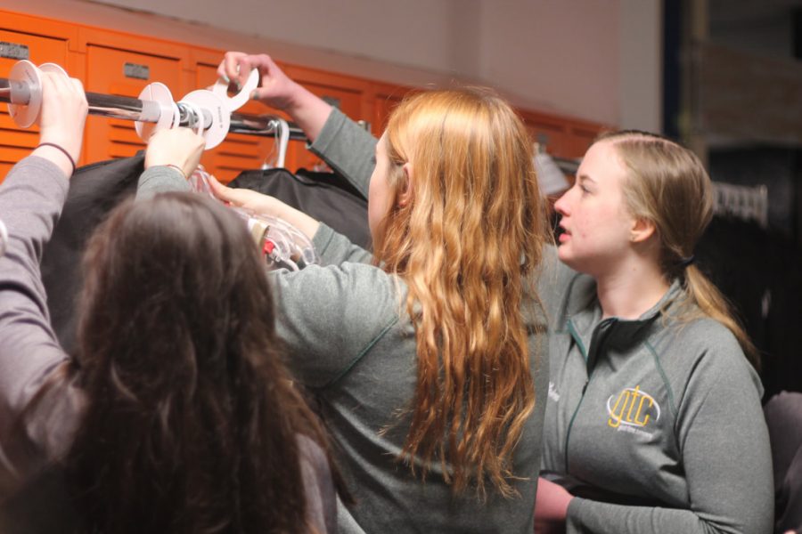 The show choir crew organizes costume racks at Benton's A Touch of Class.
 (Lauren Ernst)