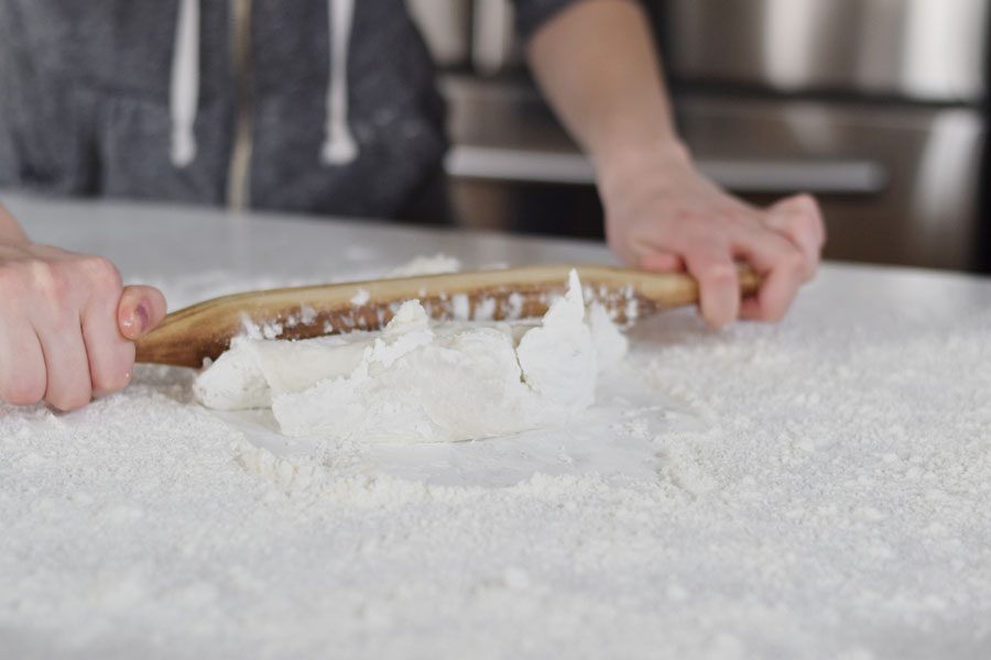 Using a rolling pin, roll the dough onto a clean surface, covered with potato starch. Parchment paper is recommended. 