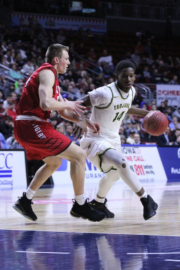 Hakeem Odunsi '18 dribbles around a defender from Cedar Falls during the first half of the game on Friday, March 9.