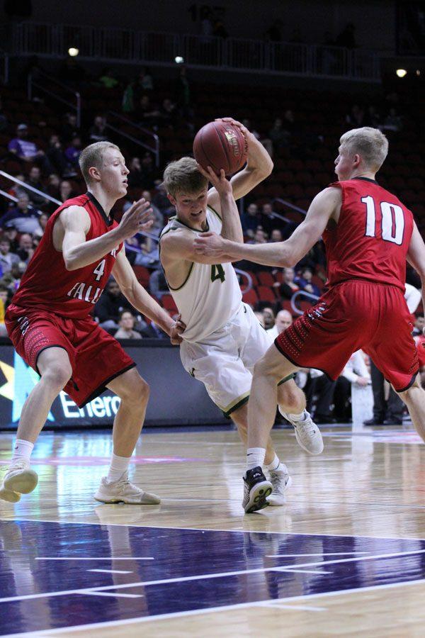 Evan Flitz '18 tries to get around Cedar Falls' 	AJ Green '18 and 	Logan Wolf '19 on Friday, March 9.