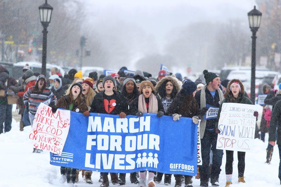 Members of Students Against School Shootings (SASS), hold up a March for our lives banner as they make their way to the Pentacrest on March 24. Nick Pryor 18, one of the leaders of SASS, was impressed by how many people came out in the snow. It was a nightmare driving downtown, and yet nearly a thousand people came out to support the movement,” Pryor said.