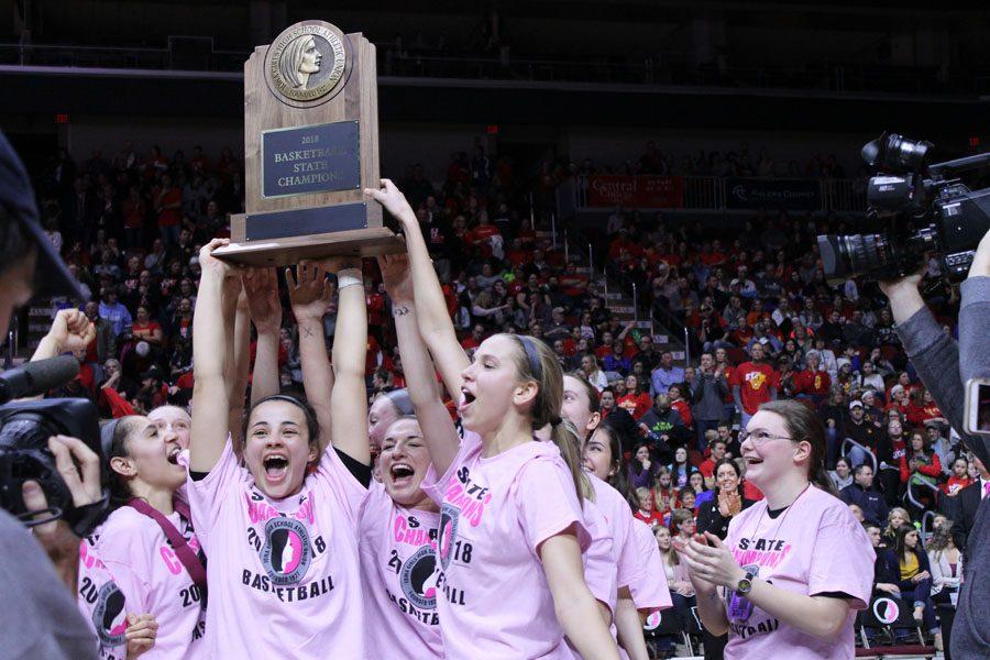 The team holds up the state champion trophy at the end of the game on Fri., March 2.