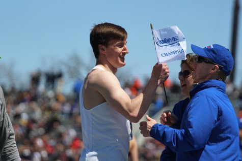 Austin West 18 holds up his Drake Relays flag after he won the 400 meter hurdle race on Saturday, April 28. He won with a time of 51.96, .02 off from breaking the meet record.