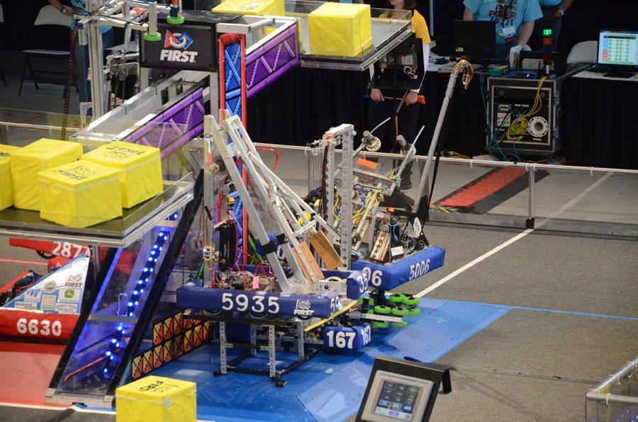 Children of the Corns robot, known as Slick, lifts two other robots in the air to boost their alliances score at the Iowa Regional.