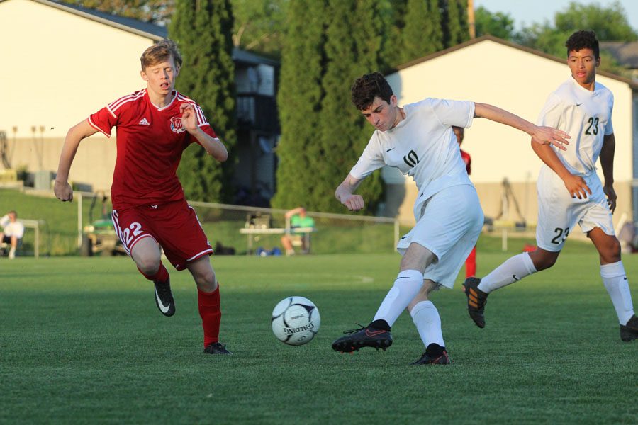 Harry Zielinski '18 passes the ball to a fellow Trojan during the second half of the game on Tuesday, May 15.