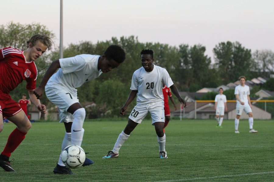 Marko Migambi '21 calls for the ball as fellow Trojan Gada Ambo '19 struggles to get it around a defender from Cedar Rapids Washington on Tuesday, May 15.