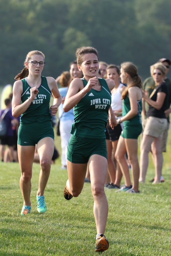 Kiara Malloy-Salgado '21 sprints towards the finish line as teammate Erica Buettner '21 trails behind her on Thursday, Aug. 23. Malloy-Salgado placed 8th in 20:34 and Buettner finished in 9th in a time of 20:36.