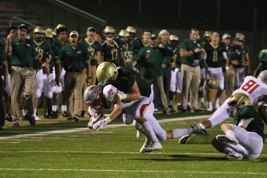 Jason Strunk '19 takes down North Scott's 	Carson Rollinger '19 during the second half of the game on Friday, Aug. 24.