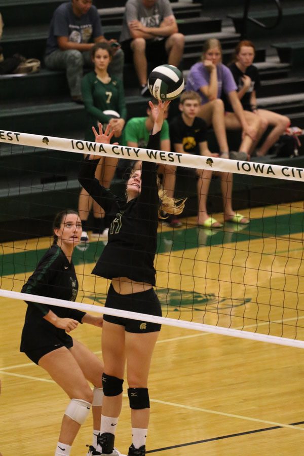 Emily Cray '19 reaches up to stop the ball from coming to the West side of the court on Tuesday, Aug. 28.