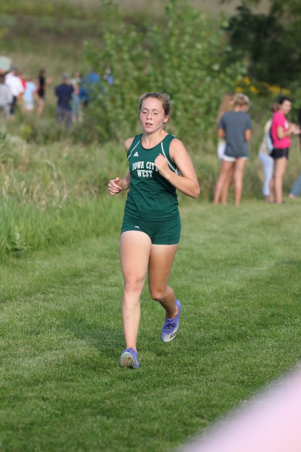 Natalie Katz '20 runs by the first mile marker during the varsity race on Thursday, Aug. 23. She placed 32nd in 22:27.