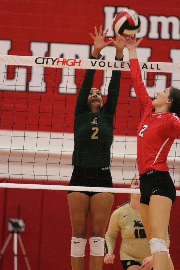 Cailyn Morgan '19 attempts to block the ball as City High's Lindsey Bolton '20 tips it over the net on Tuesday, Aug. 21. 