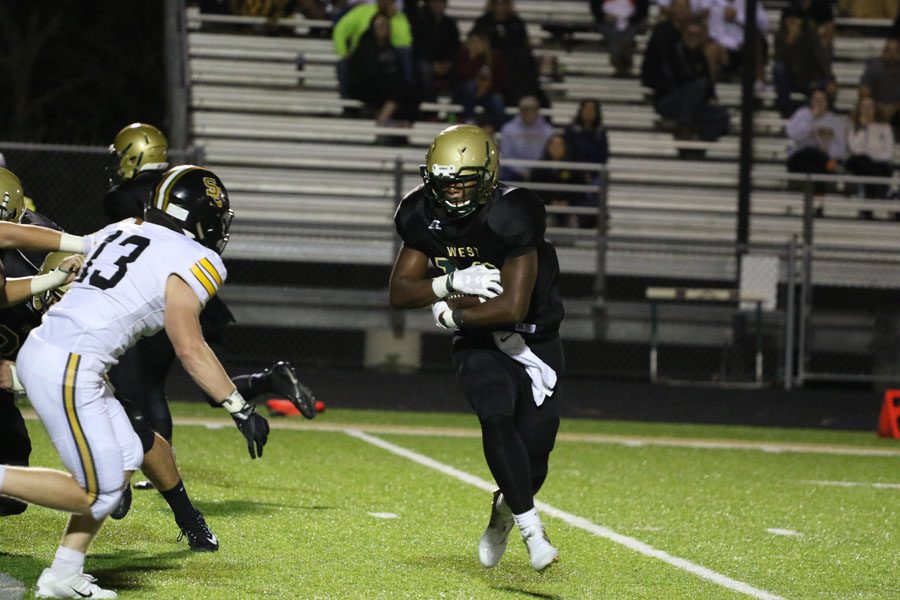 X Lubuelo '19 runs the ball towards the end zone as he tries to pass Southeast Polk's Jacob Robillard '19 on Friday, Sept. 7.