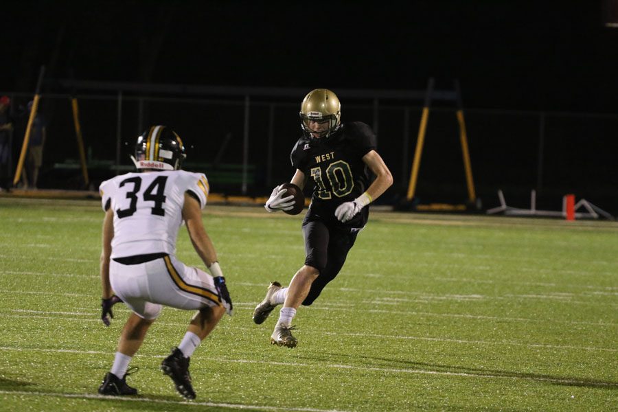 Tate Crane '20 runs around Southeast Polk's Tyler LeClair '19 on Friday, Sept. 7.