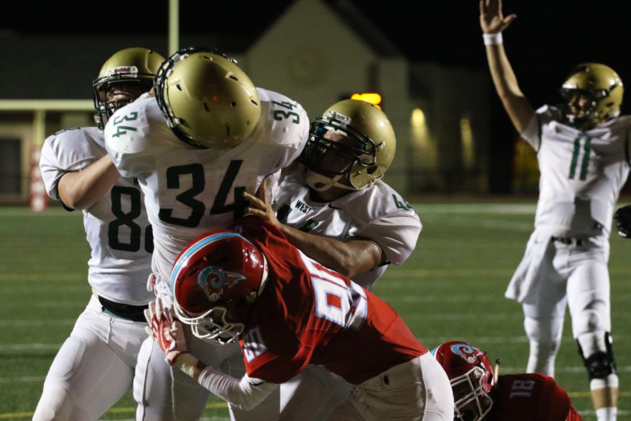 Noah Breitbach '19 and Landon Green '19 push Owen McAreavy '19 in for a touchdown during the third quarter on Friday, Sept. 14.