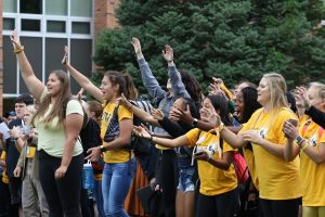 Students raise their hands in the air to grab a West High towel on Friday, Sept. 21.
