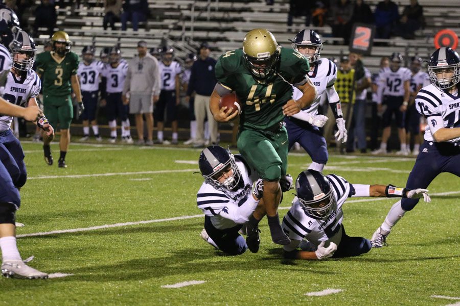 Landon Green '19 tries to escape from two Pleasant Valley defenders during the second half on Friday, Sept. 21.