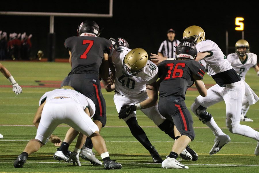 Josh Halverson '19 breaks through the offensive line to tackle Linn-Mar's Trey Martin '20 on Friday, Sept. 28.