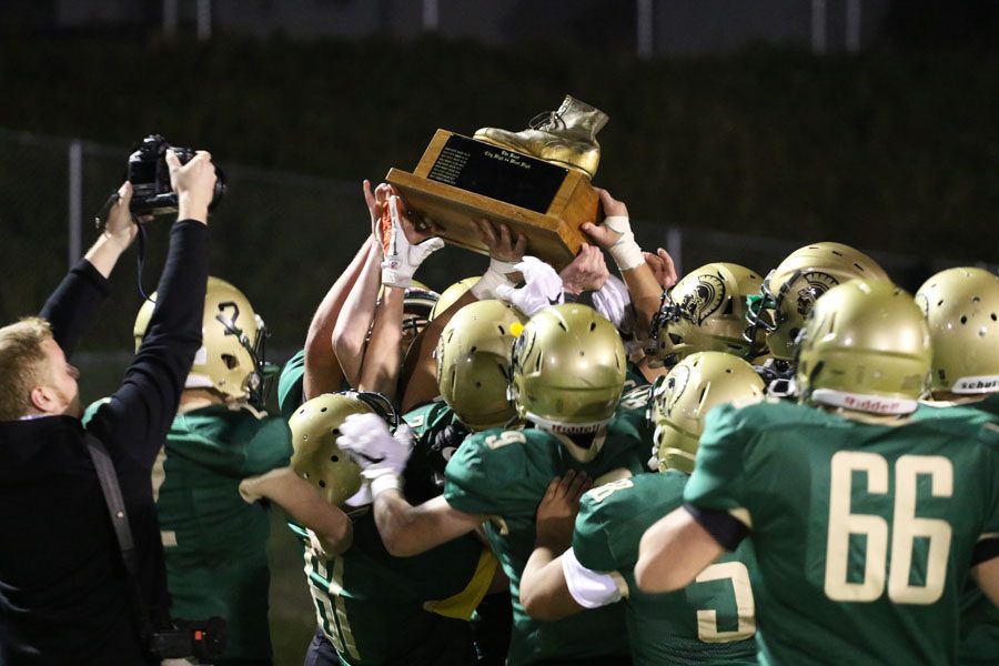 The team celebrates with the boot after their 54-13 win over City on Friday, Oct. 19, 2018.
