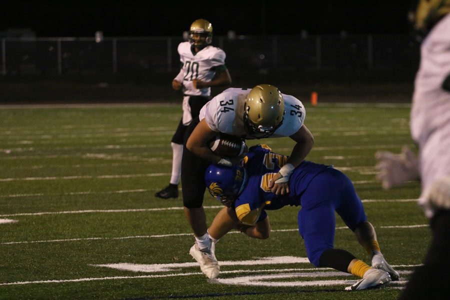 Owen McAreavy '19 runs the ball forward as Davenport North's 	Deiondre Richardson '19 tackles him on Thursday, Oct. 4.