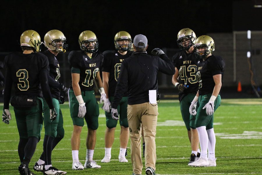 Head coach Garret Hartwig talks to a group of players during a timeout in the second half on Friday, Oct. 12.