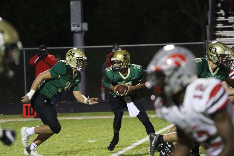 Marcus Morgan '21 looks to hand the ball off to Peter Breitbach '19 during the first quarter on Friday, Oct. 19.