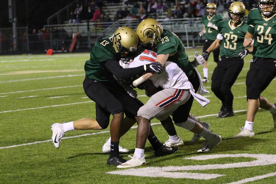 Ramey Fahal '19 and Brendan Mott '19 stop City High's Malik Kimber '19 from getting a first down on Friday, Oct. 19.