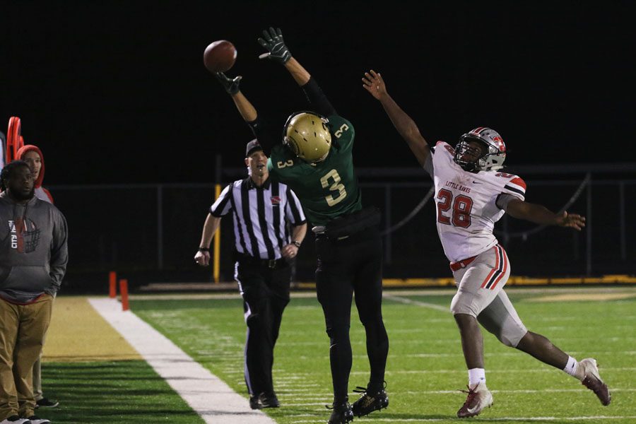 Justin Thomas '19 jumps in the air in attempt to catch the football as City High's Tonka Hickman '20 tries to block the ball on Friday, Oct. 19.