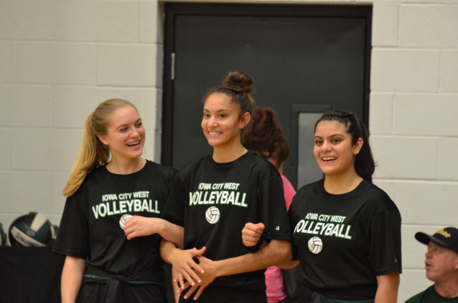 Ryann Culver '21 and Niyati Dishpande '21 laugh with Cailyn Morgan '19 as she walks to head coach, Scott Sanders on Tuesday, Oct. 9.