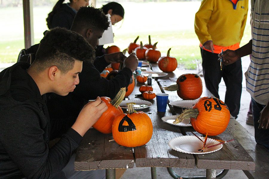 ELL students paint pumpkins into jack-o-lanterns during their event at Willow Creek Park on Wednesday, Oct. 24.
