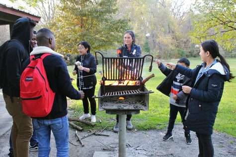 ELL students roast marshmallows over the fire at their after-school event on Wednesday, Oct. 24.