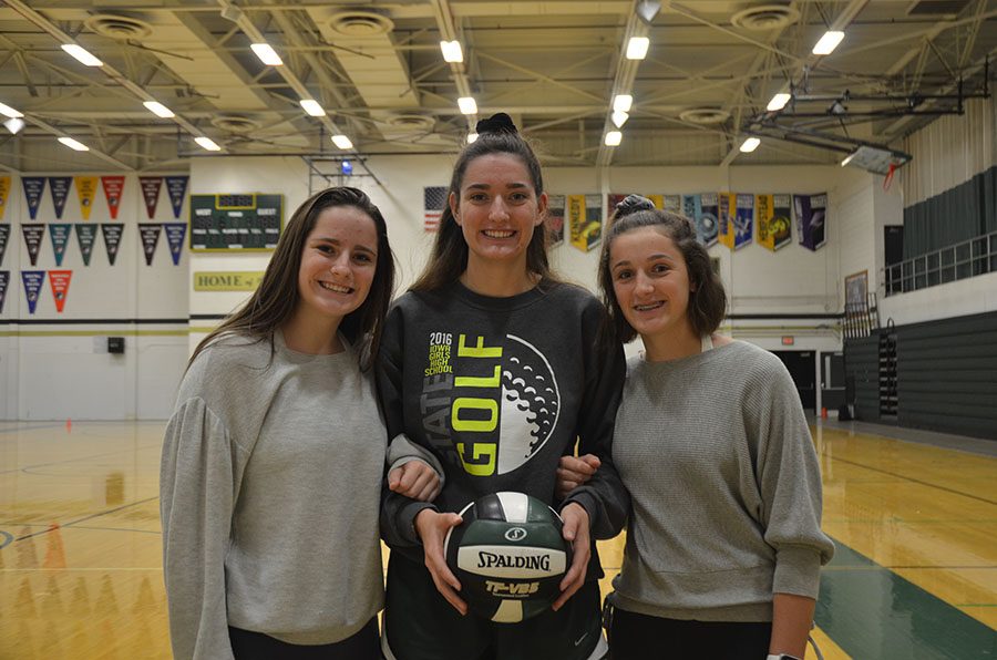 Sophia Kouba 22, Ellie Kouba 19 and Katherine Kouba 22 smile together on the volleyball court. All three Kouba sisters play for Wests varsity volleyball team this year. 