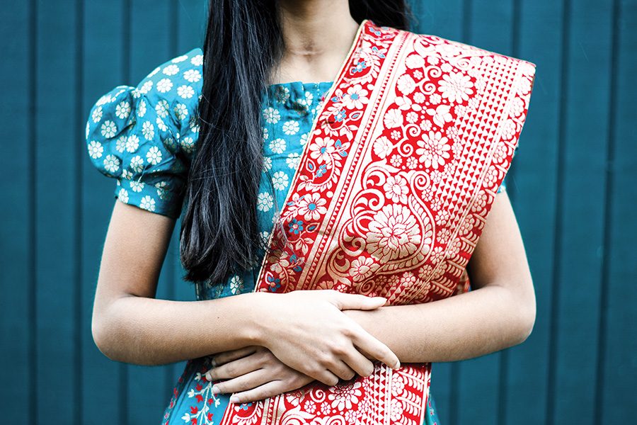 Shreya Khullar 22 holds her dupatta, an Indian accessory, in place while posing in a lehenga, a traditional Indian dress.
