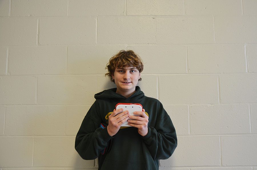 Lucas Locher 21 smiles and shows off one of his games. 