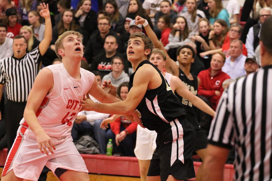 Cole Mabry '19 blocks City High's Wyatt Streeby '19 as they watch the ball go in after a three-pointer by West's Marcus Morgan '21 during the first half on Friday, Dec. 7.