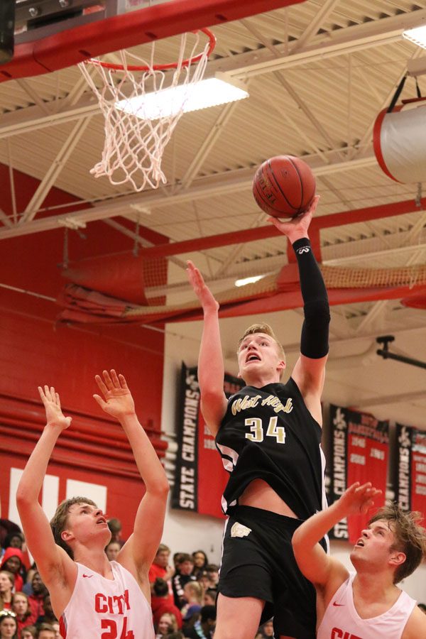 Even Brauns '20 jumps above City High's Ry Threlkeld-Weigand '19 and Luke Young '19 to score during the second half on Friday, Dec. 7.