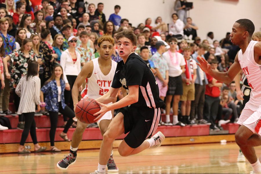 Finding an opening, Joey Goodman '20 drives towards the basket to score two points for the Trojans during the second half on Friday, Dec. 7.