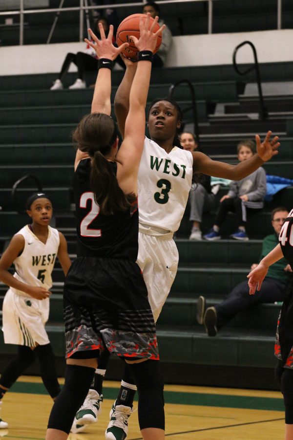 Matayia Tellis '21 goes up for a basket as Cedar Rapids Prairie's Sidney McCrea '20 tries to block her on Friday, Nov. 30.