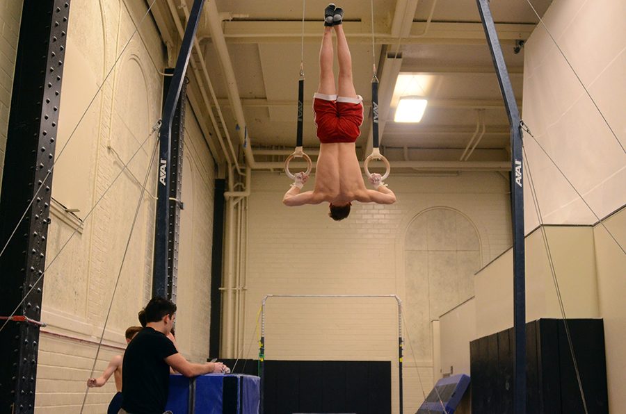 Using all of his strength, Zach Gilbaugh '21 holds himself in a upside down pull up.