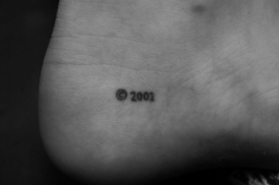 Kat Hagan 20 displays her birth year with a © 2001 stick and poke tattoo.