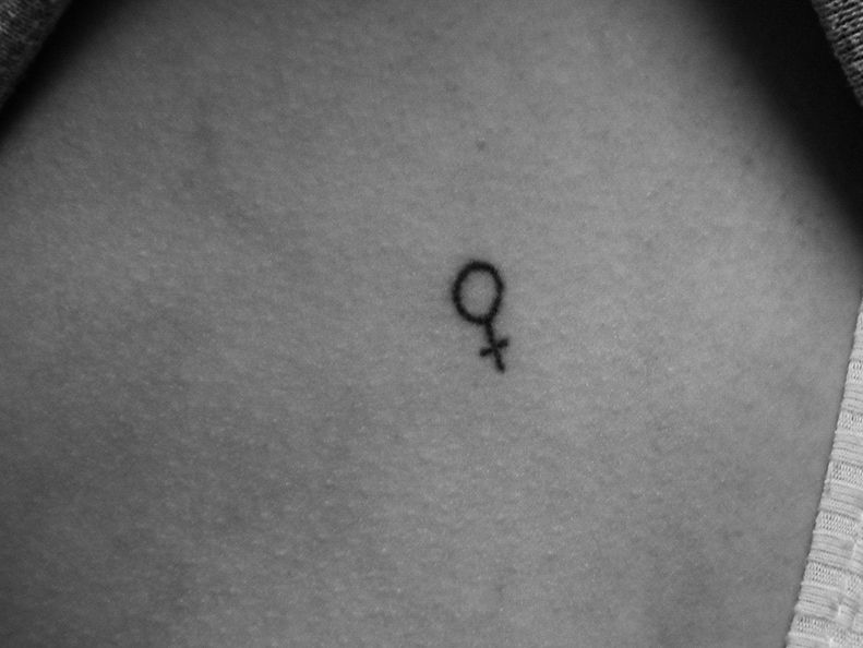 Kat Hagan 20 shows off her stick and poke tattoo of the female gender symbol.