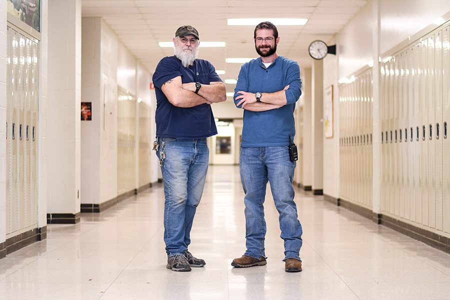 West janitors Ron Melsha and MJ Plank pose for a photo in the middle of the school hallways.