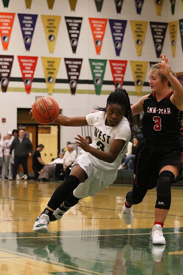 Matayia Tellis '21 drives the ball around Linn-Mar's Macey Miller '19 during the second half on Friday, Jan. 4.